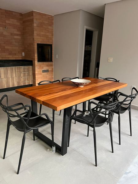 Mesa de jantar grande em madeira maciça, instalada em área externa com piscina